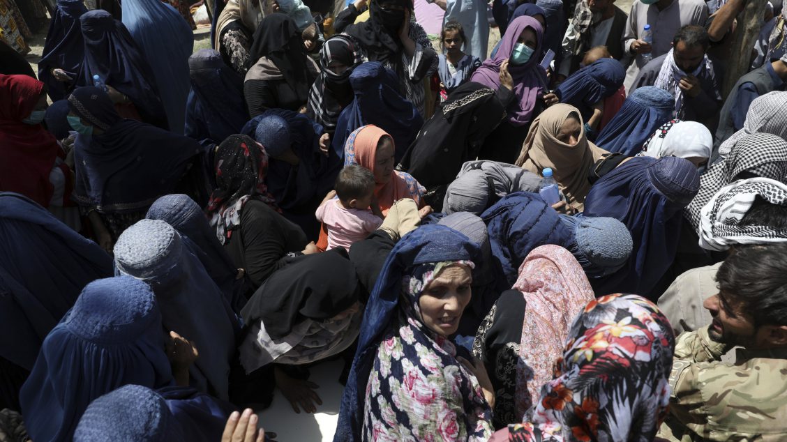 Internally displaced Afghans from northern provinces, who fled their home due to fighting between the Taliban and Afghan security personnel, wait to receive free food in a public park in Kabul, Afghanistan, Tuesday, Aug. 10, 2021.